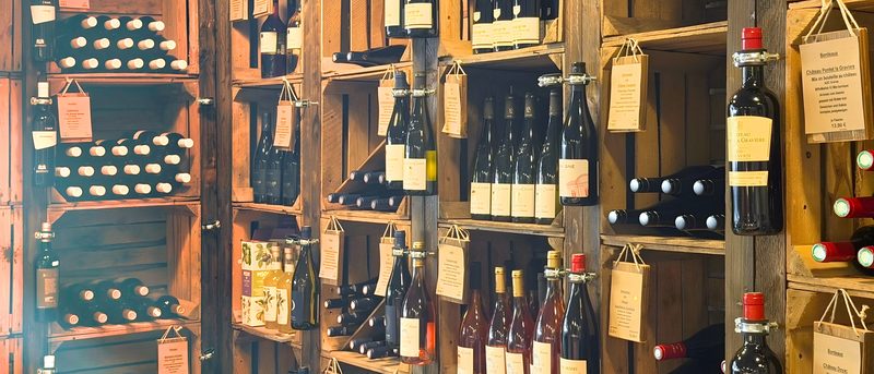 Die Weinwand von Le Marché: Holzkisten mit Rot-, Rosé- und Weißweinen und Schildern mit Herkunft und Preis