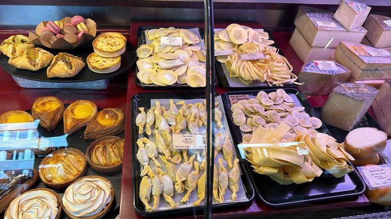 Theke mit Macarons, Quiche und Tartelettes, frischer Pasta und Käse