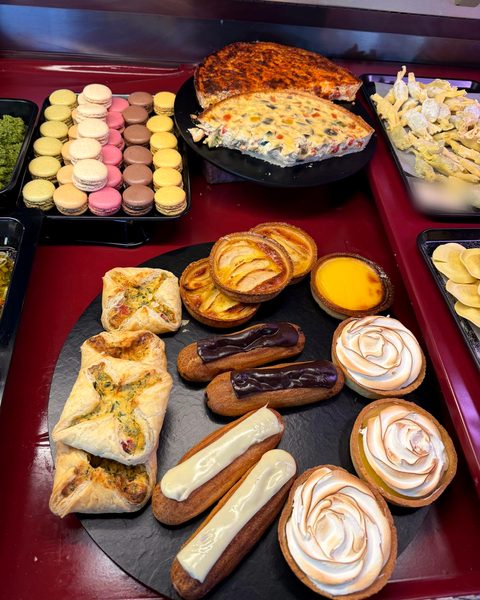 Éclairs, Tartelettes mit Baiser und Zitrone, Blätterteiggebäck und Macarons in der Theke